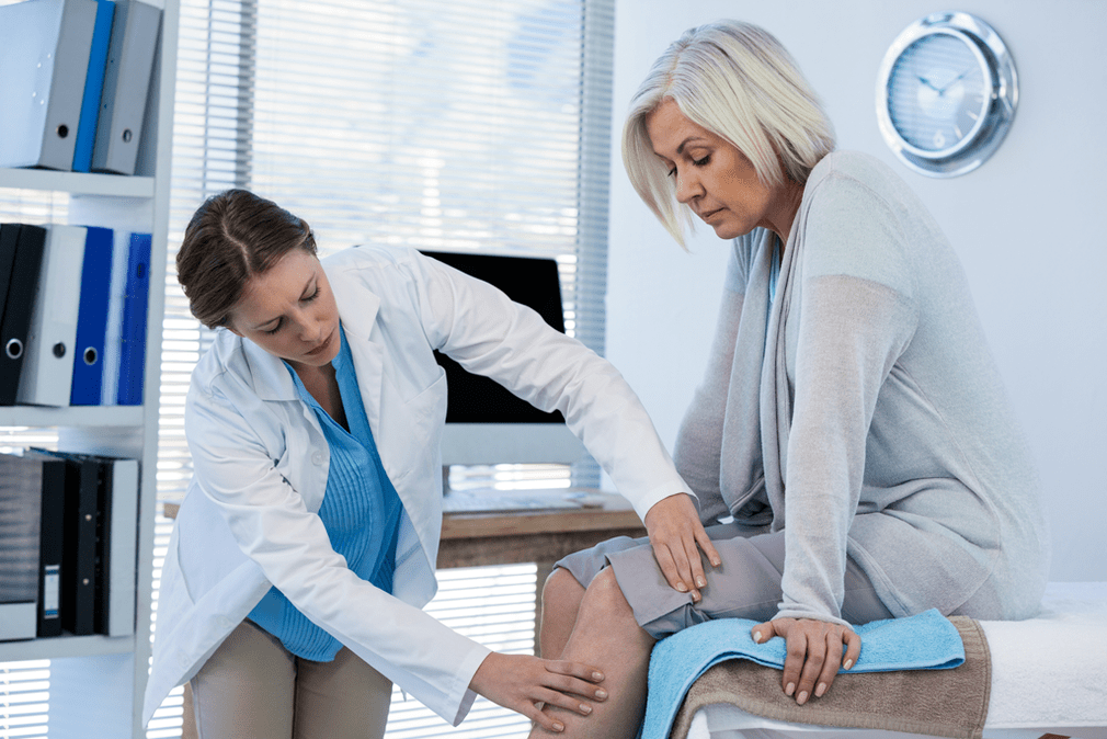 Il medico esamina un paziente con artrosi dell'articolazione del ginocchio